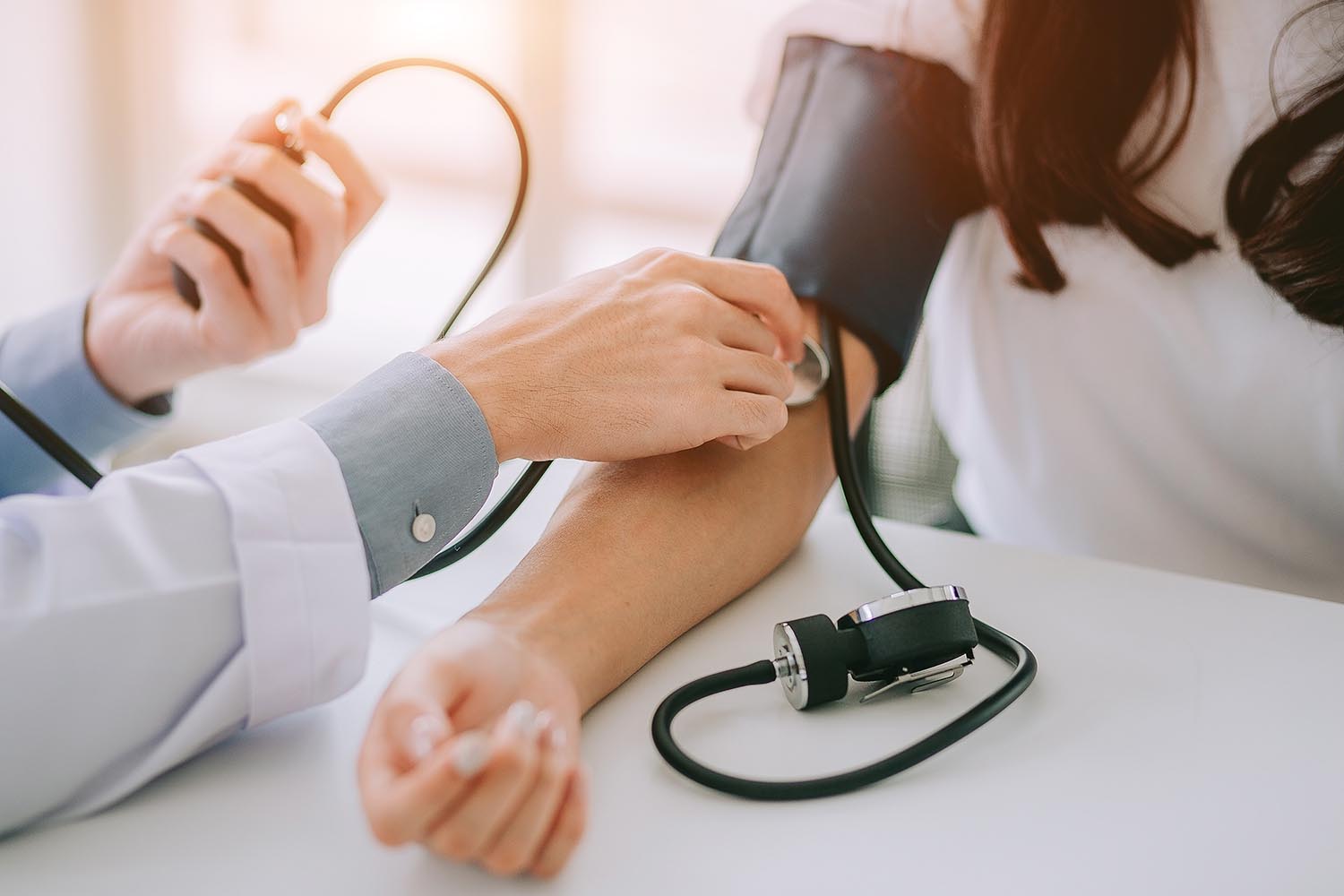 doctor taking blood pressure of a patient